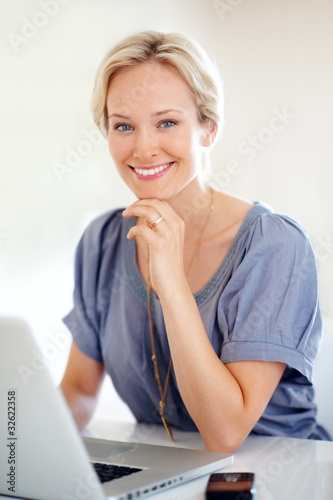 Photo: Pretty young woman working on laptop Pretty young woman working on laptop