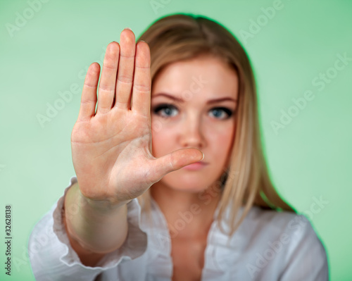 Photo: Young women holding hand in front of camera showing a sign STOP Young women holding hand in front of camera showing a sign STOP