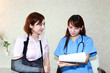 右腕の治療を終え説明している女医と安心している笑顔の女性患者