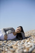 A pregnant woman lying on the beach, smiling