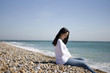 A pregnant woman sitting on the beach