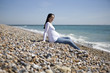 A pregnant woman sitting on the beach