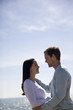 A pregnant woman and her partner embracing on the beach