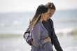 A pregnant woman and her partner walking on the beach