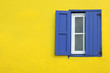 Colorful yellow house with blue shutters in Governor's Harbour