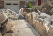 Photo: Mason building a rock wall from a pile of cut stones Mason building a rock wall from a pile of cut stones