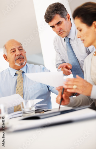 Foto: Confident people reading business document together Confident people reading business document together