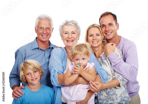 Photo: Smiling family standing together against white background Smiling family standing together against white background