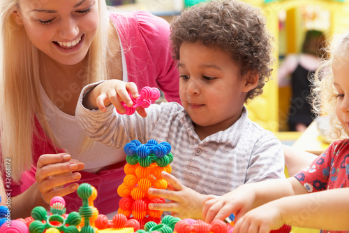 Photo: Young woman playing with boy Young woman playing with boy