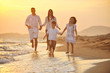 happy young family have fun on beach at sunset