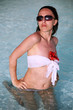 Young woman in the pool with a flower