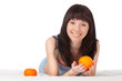 woman on bed holding orange