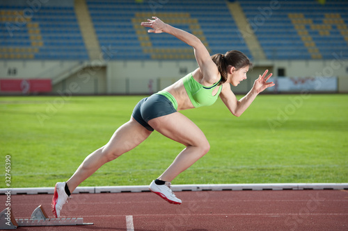 Photo: Action packed image of a female sprinter leaving starting blocks Action packed image of a female sprinter leaving starting blocks