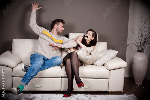 Photo: A man threatening to slap his girlfriend with taped mouth A man threatening to slap his girlfriend with taped mouth