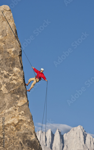 Photo: Rock climber rappelling. Rock climber rappelling.