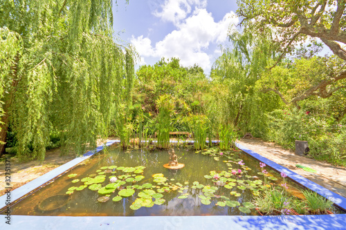 Photo: Beautiful garden with a little pond in the middle Beautiful garden with a little pond in the middle