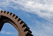 Old industrial gear segment against the blue sky