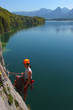 Young woman with climbing gear above alpine lake Young woman with climbing gear above alpine lake