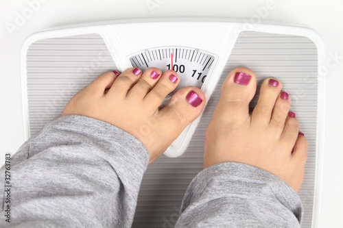Foto: Woman’ s feet on bathroom scale Woman’ s feet on bathroom scale