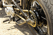 motorcycle wheel and drive-chain with golden toned highlights