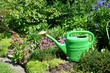 Gießkanne im Blumenbeet