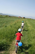 Children riding a bicycle along the banks of the river