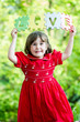 Happy little girl holdind-up words love