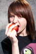 Young beautiful girl bites an red apple.