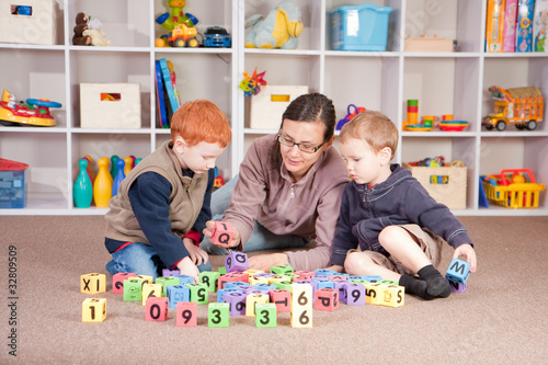 Photo: Boys playing game with kids blocks with mother Boys playing game with kids blocks with mother