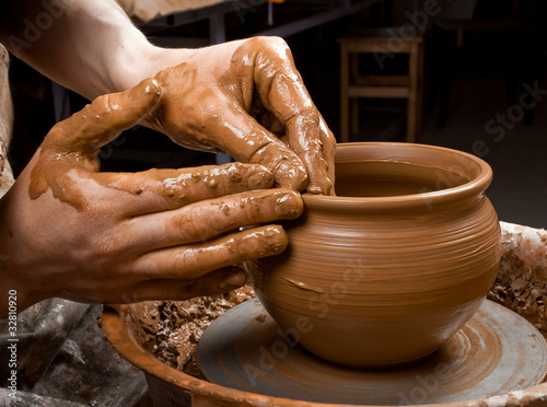 Photo: hands of a potter, creating an earthen jar on the circle hands of a potter, creating an earthen jar on the circle