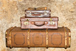 Three old leather suitcases on a grunge background