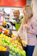 Happy young woman buying fruits