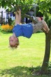 Ein kleiner Junge klettert einen Baum hoch