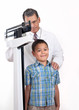 Doctor Weighing Little Boy on Weight Scale