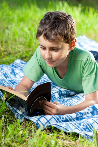 Photo: Child reading a book outdoor Child reading a book outdoor