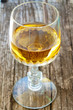 distillato ambrato in bicchiere su tavolo di legno vecchio