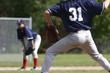 Pitcher on the mound with baseman in the background.