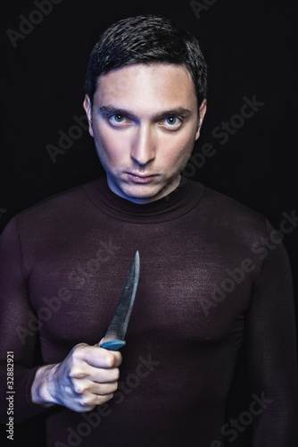 Photo: Young man in black with kitchen knife ready to stab Young man in black with kitchen knife ready to stab