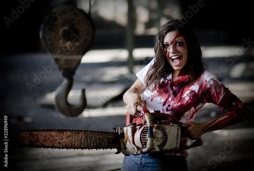 Photo: Psychotic woman with a bloody chainsaw.Vendetta/blood revenge. Psychotic woman with a bloody chainsaw.Vendetta/blood revenge.