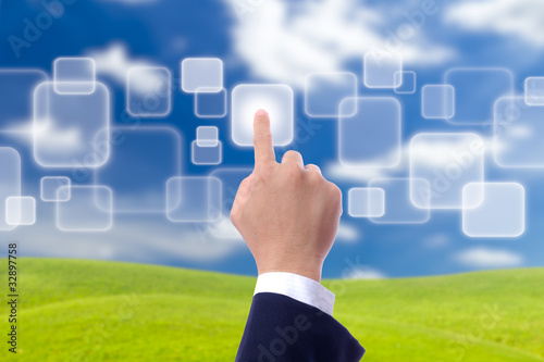Photo: hand pushing button on blue sky hand pushing button on blue sky