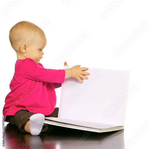 Photo: Infant baby girl enjoying and discovering books Infant baby girl enjoying and discovering books