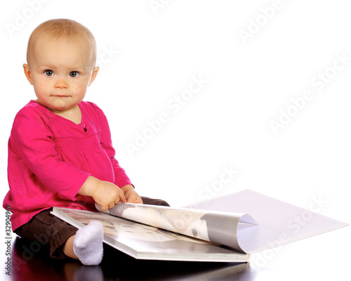 Photo: Infant baby girl enjoying and discovering books Infant baby girl enjoying and discovering books