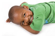 Adorable black boy with a smile laying on the floor Adorable black boy with a smile laying on the floor