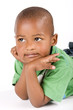 Adorable black boy laying on the floor staring into space Adorable black boy laying on the floor staring into space
