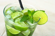 Photo: Mojito with rum, limes, mint and ice cubes on sand Mojito with rum, limes, mint and ice cubes on sand