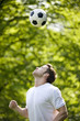 A young man playing with a football
