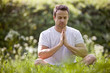 A young man meditating outdoors
