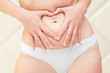 Hands in the form of heart on a stomach of the woman