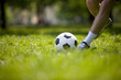 A young man kicking a football outdoors