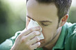 Close-up of a young man blowing his nose